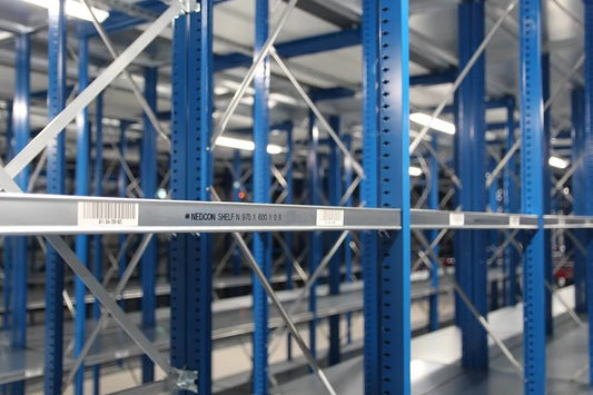 Zbliżenie na regał magazynowy z oznaczeniami i kodami kreskowymi systemu kontroli nośności zabezpieczającego przed przeciążeniem