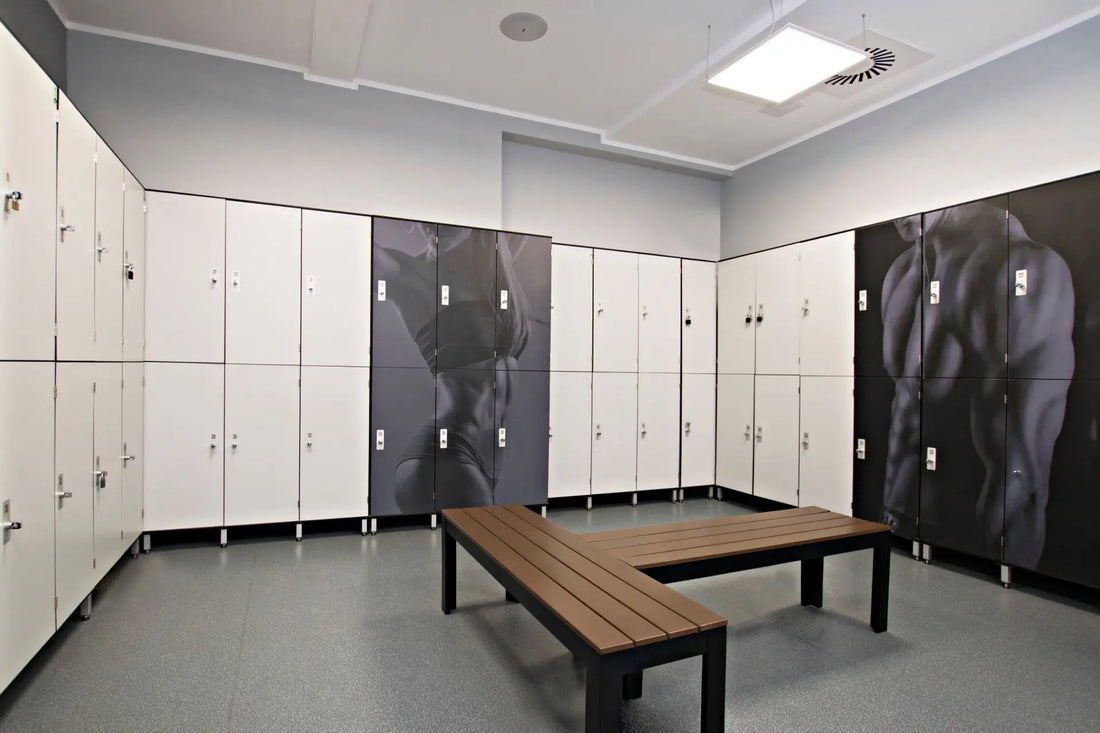 Szafki socjalne w szatni sali gimnastycznej z odzieżą sportową i sprzętem gimnastycznym przechowywanymi w metalowych schowkach