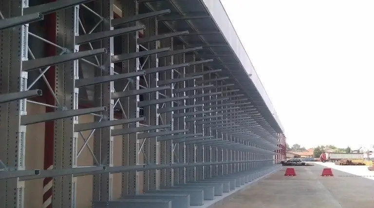 Regały wspornikowe w warsztacie samochodowym z długimi częściami samochodowymi jak rury wydechowe i elementy podwozia na wysuwnych ramionach