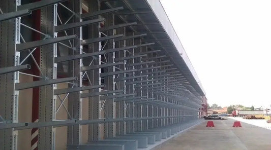 Regały wspornikowe w warsztacie samochodowym z długimi częściami samochodowymi jak rury wydechowe i elementy podwozia na wysuwnych ramionach