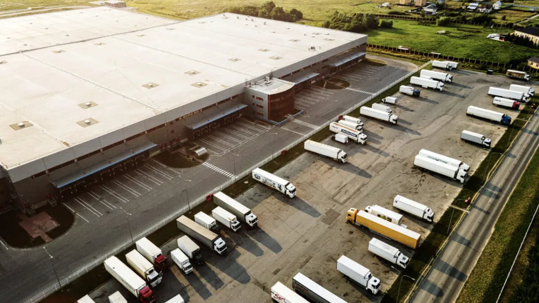 Yard z lotu ptaka z zaparkowanymi ciężarówkami do last mile delivery w e-commerce, optymalizacja ostatniego etapu dostawy