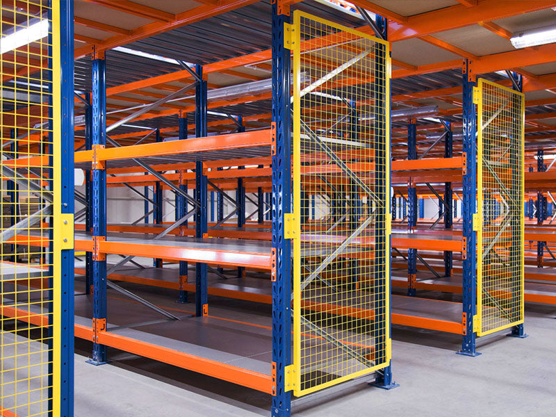 Regały półkowe z metalową siatką zabezpieczającą po bokach, stosowane na zewnątrz do bezpiecznego składowania różnych materiałów, ochrona przed zsuwaniem się przedmiotów